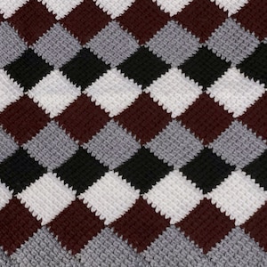 May include: A crocheted blanket with a diamond pattern in shades of burgundy, gray, black, and white.
