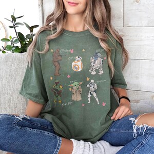 May include: A white ceramic mug with a black handle and the text "But First, Coffee" in a black, handwritten-style font. The mug is on a white surface.