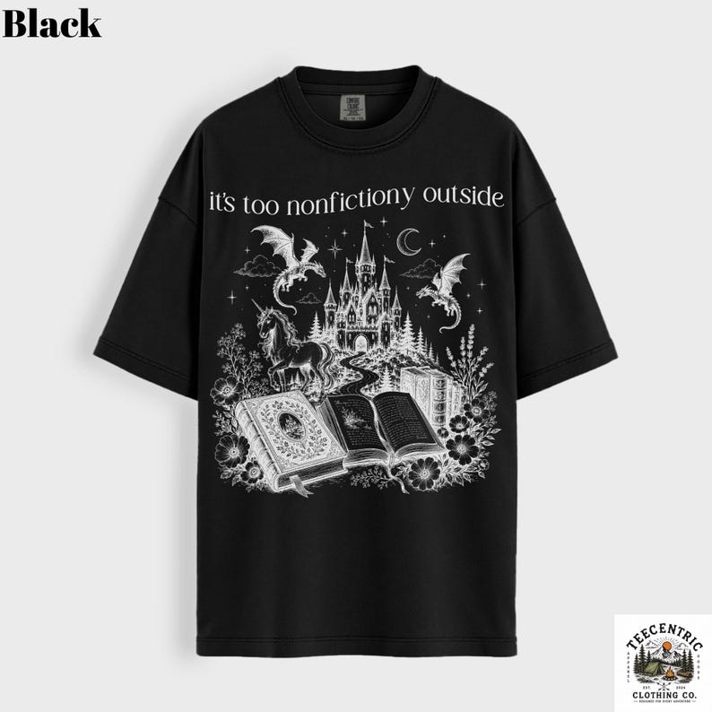 May include: Black t-shirt with a fantasy-themed graphic. The design features a castle, dragons, a unicorn, and open books, with the text "it's too nonfictiony outside". The shirt has short sleeves and a crew neck.