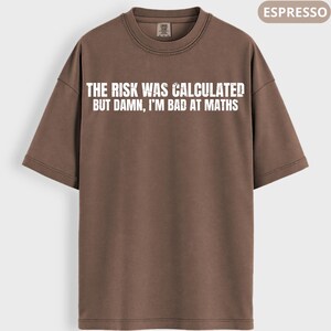 Peut inclure: T-shirt couleur expresso avec l'inscription blanche : "THE RISK WAS CALCULATED BUT DAMN, I'M BAD AT MATHS". Le t-shirt a un col rond et des manches courtes. Le v&ecirc;tement est de couleur unie.