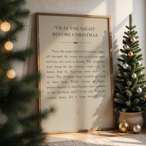Peut inclure: Un cadre avec le texte "Twas the Night Before Christmas", avec un petit sapin de Noël à droite. L'arbre est décoré d'ornements dorés et argentés. Un deuxième sapin de Noël avec des orbes lumineux est à gauche.