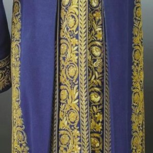 May include: A long, royal blue garment with elaborate gold embroidery. The embroidery features floral and leaf patterns, with large gold buttons. The garment appears to be made of a heavy fabric, possibly velvet.