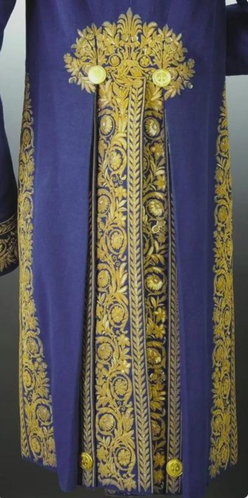 May include: A long, royal blue garment with elaborate gold embroidery. The embroidery features floral and leaf patterns, with large gold buttons. The garment appears to be made of a heavy fabric, possibly velvet.