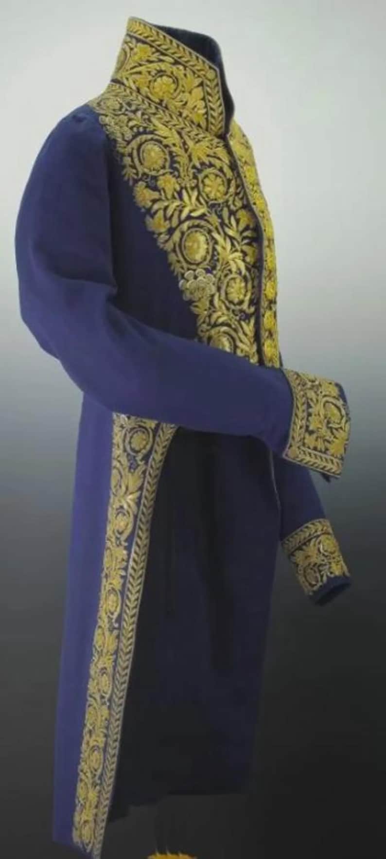 May include: A long, navy blue coat with ornate gold embroidery. The embroidery is detailed along the collar, cuffs, and front edges. The coat has long sleeves and a tailored fit, suggesting formal wear.