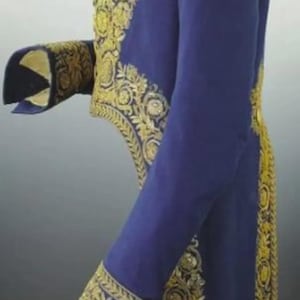 May include: A side view of a royal blue jacket with elaborate gold embroidery. The jacket features ornate floral and scrollwork patterns along the edges, cuffs, and collar, creating a regal appearance. The sleeves are long and the jacket has a tailored fit.
