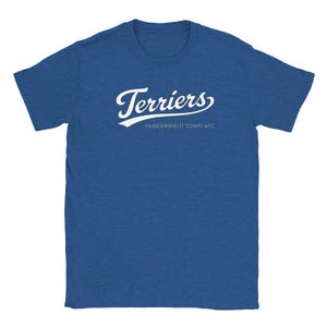 Könnte beinhalten: Blaues T-Shirt mit dem Wort "Terriers" in weißer Schrift auf der Brust. Darunter steht "HUDDERSFIELD TOWN AFC". Das T-Shirt besteht aus einem weichen Material. Ein lässiges Oberteil für Fans.