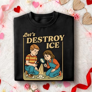 May include: Black sweatshirt with a graphic of two children with a magnifying glass and a lighter, melting ice. The text "Let's DESTROY ICE" is above the illustration in a vintage style.