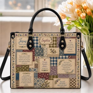 May include: A rectangular handbag featuring a patchwork design with floral and plaid patterns in muted tones. The bag displays several printed religious quotes and the name Sophia. It has black leather handles and a detachable shoulder strap.