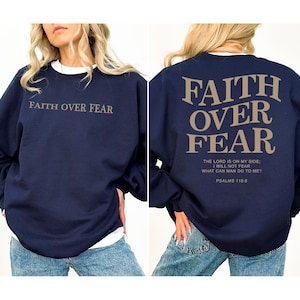 May include: Navy blue sweatshirt with the text "FAITH OVER FEAR" printed on the front and back. The back of the sweatshirt also includes the text "THE LORD IS ON MY SIDE: I WILL NOT FEAR WHAT CAN MAN DO TO ME? PSALMS 118:6".