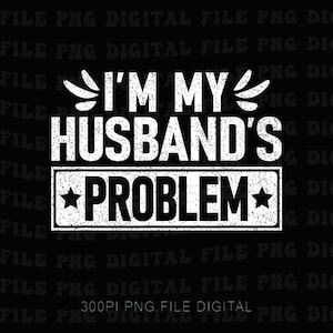Może przedstawiać: Czarny plik cyfrowy z białym tekstem, który brzmi "I'M MY HUSBAND'S PROBLEM" pogrubioną, postarzaną czcionką. Słowo "PROBLEM" znajduje się w prostokątnym pudełku z gwiazdkami po każdej stronie. Elementy dekoracyjne znajdują się nad słowami "I'M MY".