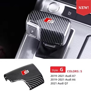 May include: A carbon fibre pattern gear shift knob cover featuring an S logo in a red square. The cover is designed for specific Audi models including the 2019-2021 Audi A7, 2019-2021 Audi A6, and 2021 Audi Q7. The text NEW is visible in a red banner.