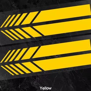 Pode incluir: Dois autocolantes retangulares com um design gráfico amarelo brilhante. Cada autocolante consiste numa série de riscas diagonais paralelas no lado esquerdo que transitam para duas barras horizontais sólidas até à extremidade direita.