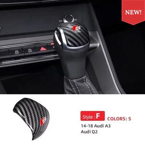 Può includere: Una copertura per pomello del cambio in fibra di carbonio con logo S rosso e bianco. L'accessorio è progettato per i modelli Audi A3 e Audi Q2 dal 2014 al 2018, presentando un motivo nero e grigio testurizzato con finitura lucida ed etichetta rossa Style F.