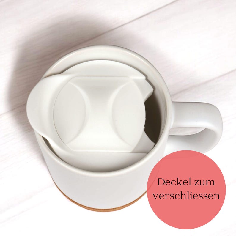 May include: A white ceramic mug with a matching lid. The lid is designed to fit snugly inside the mug, with a small opening for drinking. The mug sits on a light brown coaster. The image includes the text "Deckel zum verschliessen".