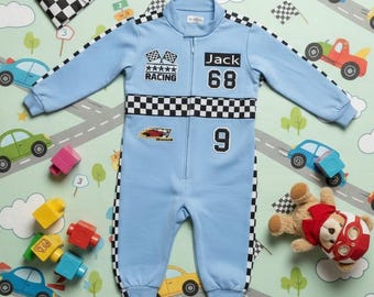 May include: A light blue racing-themed jumpsuit with black and white checkered accents, the text "Jack 68" and the number "9". The jumpsuit has a zipper closure and is surrounded by toy cars and a checkered flag.