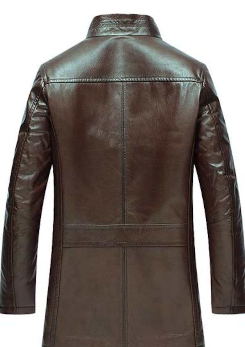 May include: A brown leather jacket with a classic design. The jacket features a collared neckline, long sleeves, and a tailored fit. The back of the jacket has a horizontal seam across the upper back and a vertical seam down the center.