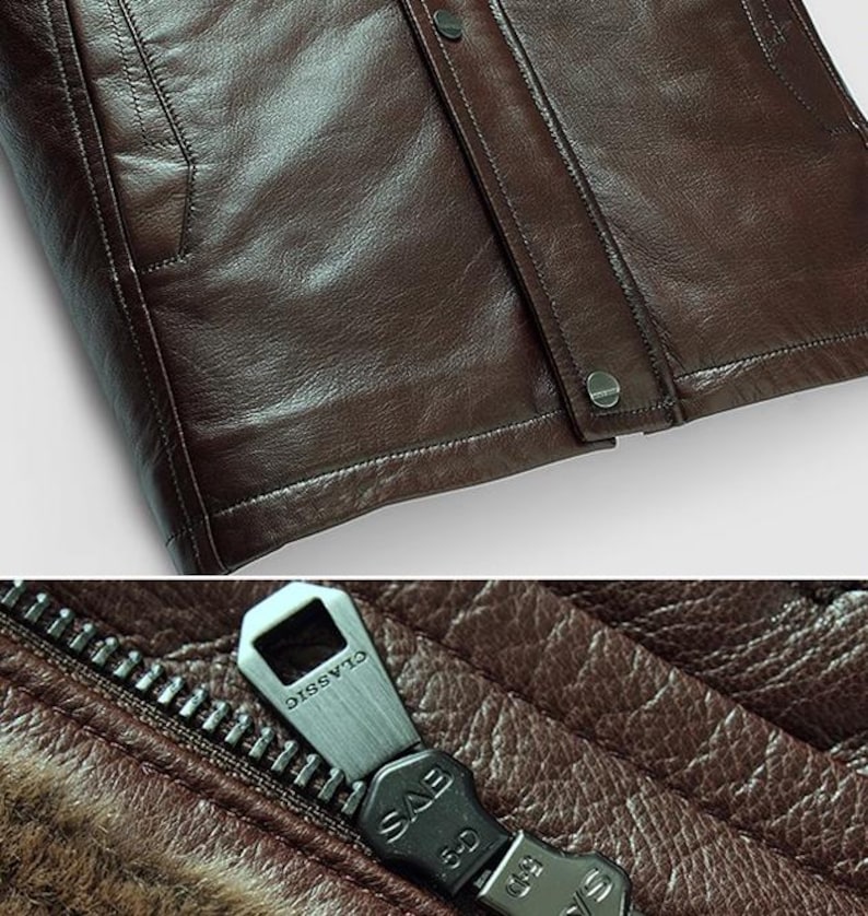 May include: Close-up of a brown leather jacket. The jacket features a zipper with the word "CLASSIC" on the pull tab. The leather has a textured appearance, and the jacket has a buttoned closure.