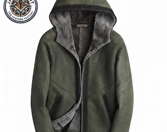 May include: An olive green hooded jacket featuring a dark gray faux fur lining, a front zipper closure, and black trim accents on the cuffs, pockets, and hood edge. The interior label displays the text JacketJoint The Leather Factory.