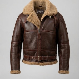 May include: A brown leather jacket with a shearling collar and lining. The jacket has a front zip, a waist belt with a buckle, and the brand name "Jacketjoint" on a label.