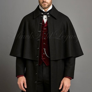 Op de afbeelding: Een zwart wollen cape- en overjasensemble. De outfit bevat een rood fluwelen vest, een wit overhemd met kraag en een zwarte vlinderdas. De afbeelding bevat de tekst "Hawk Field Legacy".