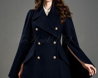 May include: A navy blue double-breasted coat with gold buttons and a cape-like design. The coat features a tailored fit and a classic silhouette, suitable for various occasions. The Hawk USA logo is visible.