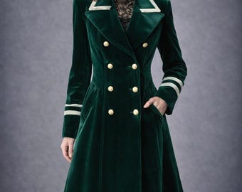 May include: A long, emerald green velvet coat with a double-breasted design and gold buttons. The coat features white trim on the collar and cuffs, and a black lace hemline. The coat has a tailored fit and a classic, elegant style.