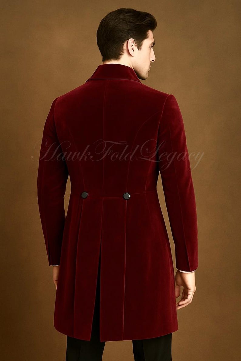 May include: A burgundy velvet coat with a high collar and two black buttons at the waist. The coat has a long, tailored fit and a split back. The text "Hawk Fold Legacy" is visible in the image.