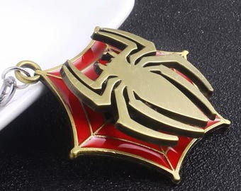 Llavero de Spiderman color bronce con dije de telaraña roja, regalo para geeks, ideal para mochilas, llaves y bolsos.
