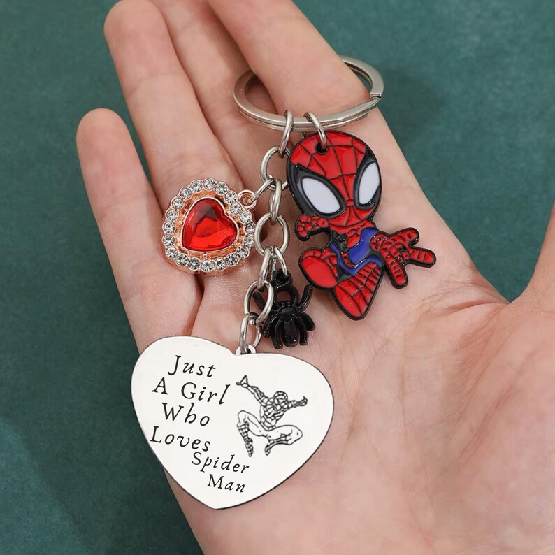 Puede incluir: Llavero con un dije de Spider-Man rojo y negro, un dije en forma de coraz&oacute;n con una gema roja y una etiqueta en forma de coraz&oacute;n con el texto "Just A Girl Who Loves Spider-Man". Incluye un peque&ntilde;o dije de ara&ntilde;a negra.