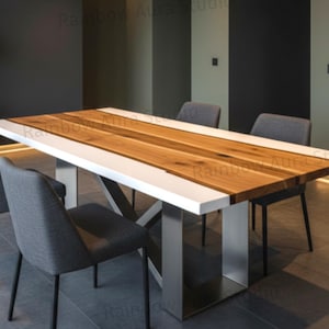 May include: A modern dining table with a rectangular wooden top, white edges, and a stainless steel base. The table is surrounded by four gray upholstered chairs. The table's dimensions are approximately 72 inches long and 36 inches wide.