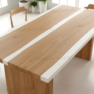 May include: A large, rectangular wooden dining table with a light wood grain finish and a white border. The table has a solid base and is surrounded by wooden chairs. The text "Rainbow Aura Studio" is visible.