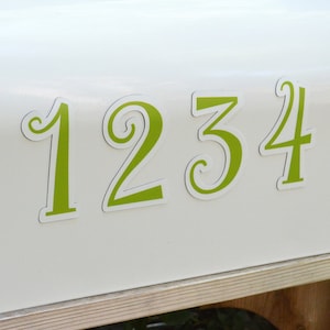 May include: White mailbox with a red flag and green numbers 1234 on the front.