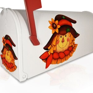 May include: White mailbox with a painted scarecrow design. The scarecrow has a brown hat, orange hair, and a yellow face. The mailbox has a red flag.