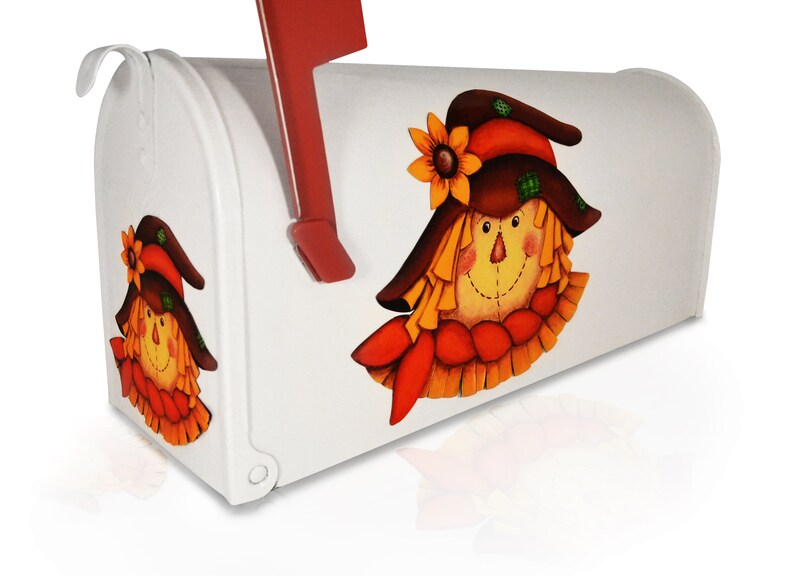 May include: White mailbox with a painted scarecrow design. The scarecrow has a brown hat, orange hair, and a yellow face. The mailbox has a red flag.