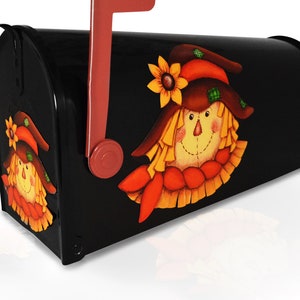 May include: Black mailbox with a painted scarecrow design. The scarecrow has a brown hat, yellow hair, a red and orange scarf, and a friendly face.