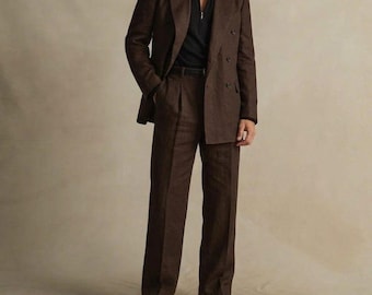 May include: A brown linen suit, featuring a double-breasted jacket and matching trousers. The suit is paired with a black zip-up shirt and black shoes. The ensemble is a classic, tailored look.