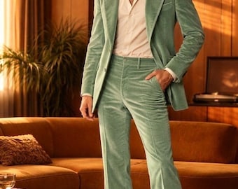 Puede incluir: Un traje de pana verde claro, que consta de una americana y pantalones acampanados, combinado con una camisa rosa claro con cuello. El traje se lleva con zapatos de cuero marrón. El escenario es un salón de estilo retro.