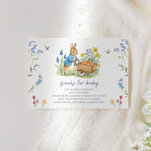May include: A baby shower invitation card featuring a watercolor illustration of a rabbit pushing a cart of carrots. The card has text that reads "Books for baby" and asks guests to bring a book instead of a card. Floral accents frame the card.