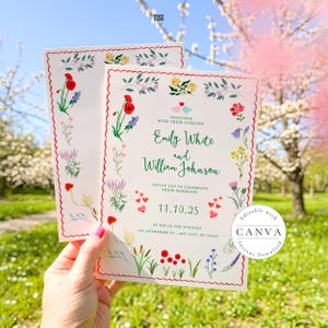 A beautiful wedding invitation card held against a scenic backdrop of blooming spring trees. The card features a scalloped red border with colorful illustrated wildflowers, including red poppies and lavender. It invites guests to celebrate the marriage of Emily White and William Johnson on November 10, 2025, at six in the evening. The charming design includes bird illustrations and a Canva watermark, set in an idyllic outdoor garden.