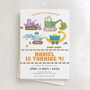 May include: A white invitation card with colorful dinosaur-themed illustrations of construction vehicles. The text reads "DANIEL IS TURNING 4!" and includes party details. The card is layered on top of a white envelope.