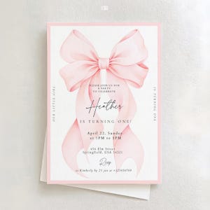 May include: A pink and white birthday party invitation featuring a large watercolour bow. The invitation reads "Please join us for a party to celebrate Heather is turning one!" with event details and RSVP information.