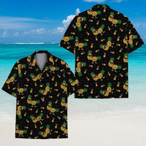 Könnte beinhalten: Schwarzes kurzärmeliges Hemd mit einem sich wiederholenden Muster aus gelben Ananas mit Sonnenbrille. Die Ananas sind mit kleineren Ananas und weißen Punkten durchsetzt. Das Hemd hat einen klassischen Kragen, ideal für den Urlaub.