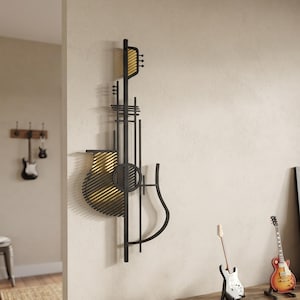 Puede incluir: Una escultura de pared de metal que presenta una silueta de guitarra estilizada en negro con listones horizontales en tono dorado. El diseño incorpora líneas verticales y formas geométricas, creando una representación abstracta del instrumento.