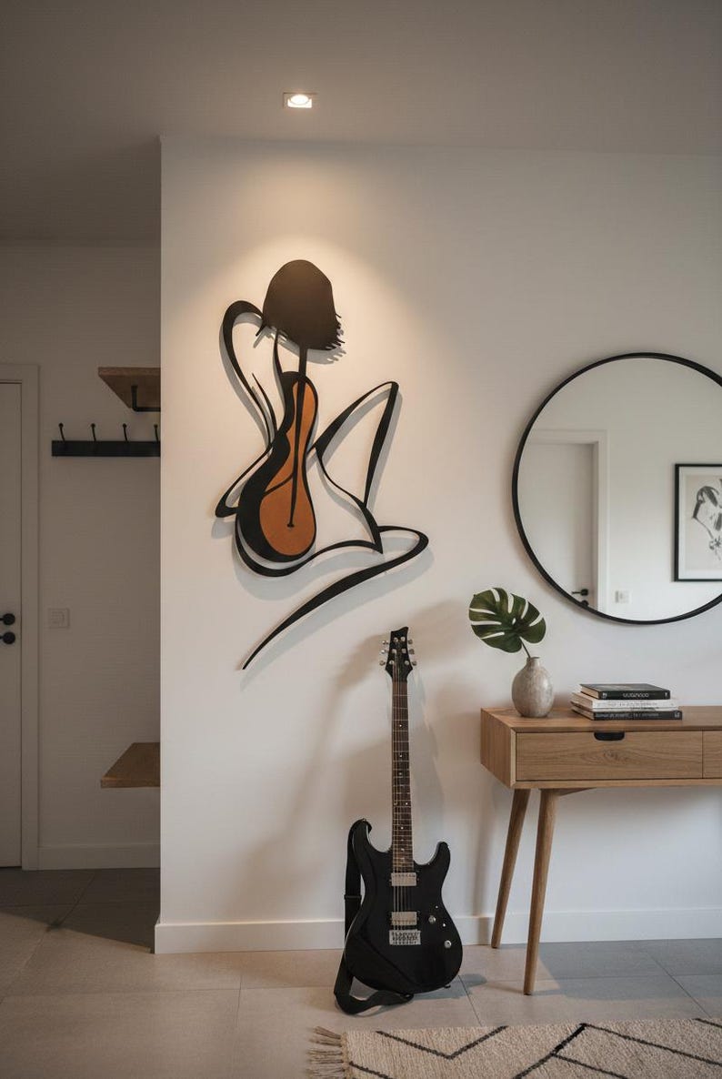 May include: A modern interior featuring a black electric guitar leaning against a white wall. A large, abstract metal wall art piece depicts a figure with a guitar. A round mirror and wooden console table complete the scene.