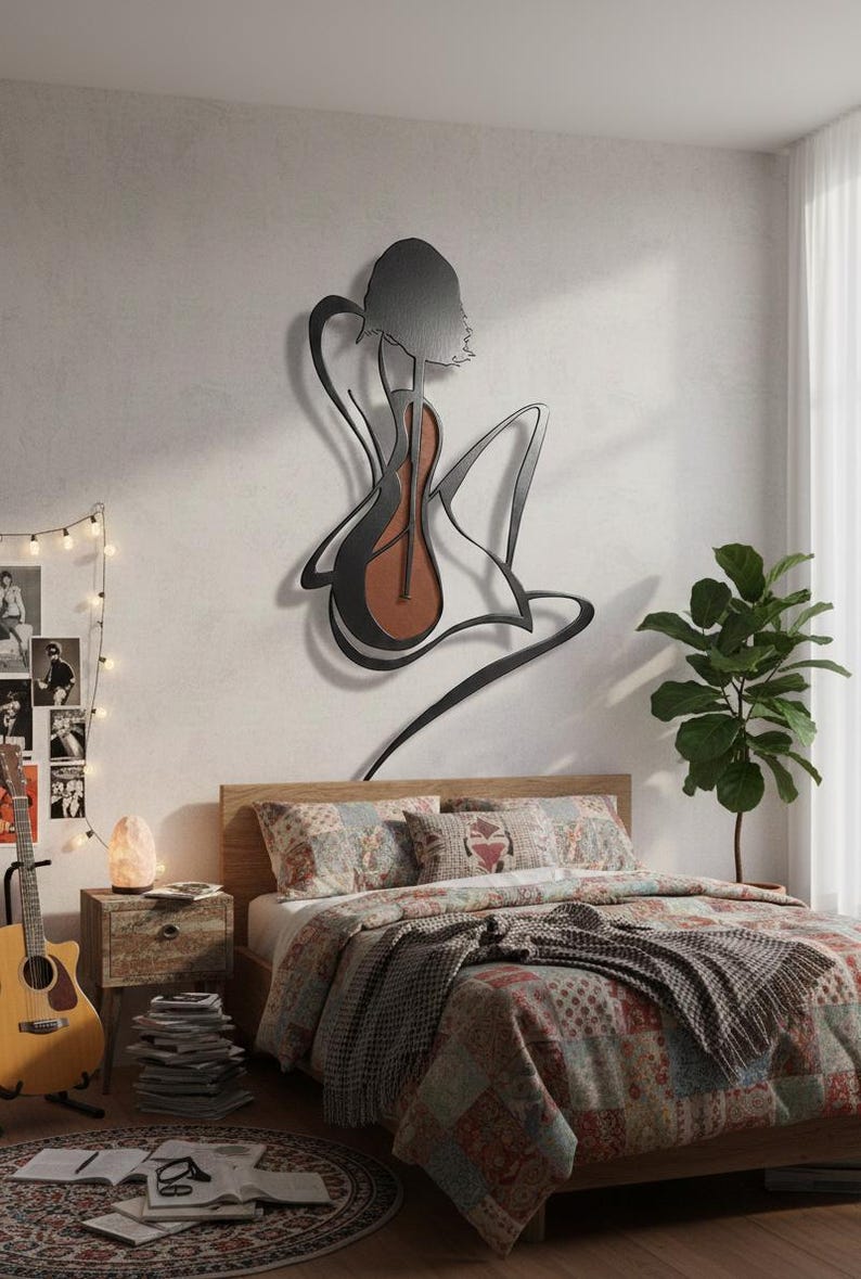 May include: A metal wall art piece depicting a woman with a guitar. The artwork is black with a brown guitar body. The bedroom features a bed with a patterned quilt, a guitar, and a small side table with a lamp.