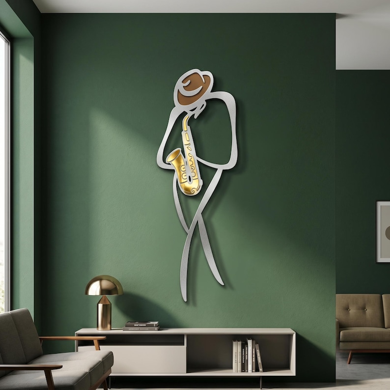 May include: A wall-mounted metal art piece depicting a stylized figure wearing a brown hat and playing a gold saxophone. The figure is outlined in a silver metallic finish, creating a minimalist silhouette that stands out against the wall surface.