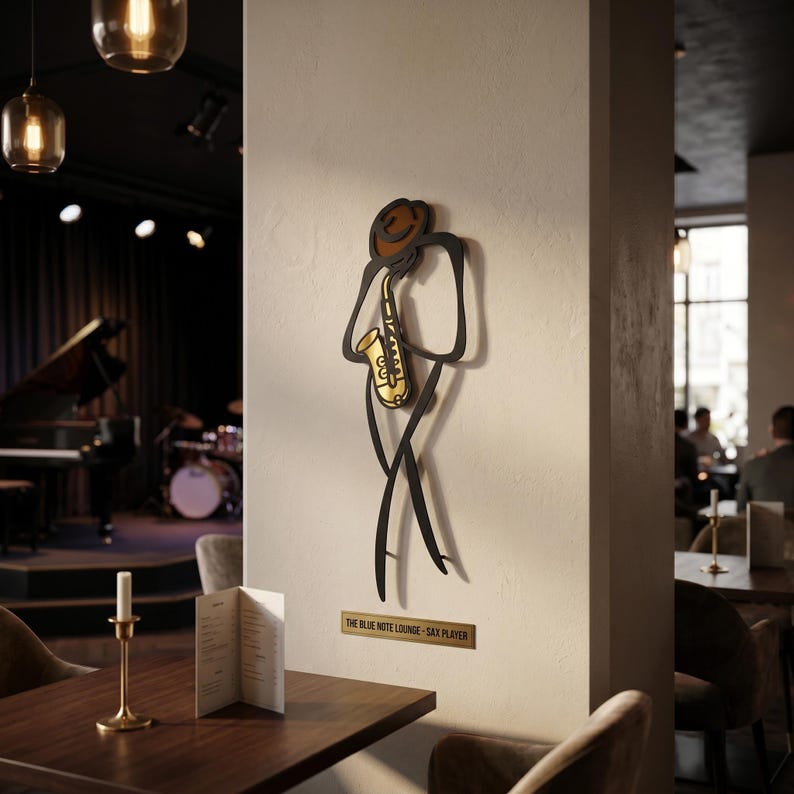 May include: A wall-mounted metal art piece depicting a stylized figure playing a gold saxophone, featuring a brown hat and black outline. Below the figure, a rectangular plaque displays the text THE BLUE NOTE LOUNGE - SAX PLAYER.