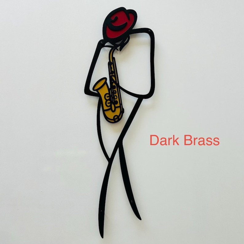 May include: A black metal wall art piece depicting a stylized figure wearing a red hat and playing a yellow saxophone. The design features clean, minimalist lines forming the silhouette of a musician. The text Dark Brass is printed in red.