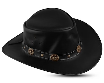 May include: A black leather cowboy hat with a wide brim. The hat features a decorative band with bronze-colored circular accents and white stitching. The hat has a rounded crown and is suitable for outdoor wear.