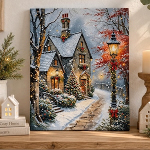 Könnte beinhalten: Ein quadratischer Leinwanddruck, der ein verschneites Steinhäuschen in der Dämmerung zeigt, geschmückt mit Weihnachtskränzen und Lichtern. Eine beleuchtete Laterne im Vintage-Stil steht auf einem Steinweg, umgeben von Bäumen mit rotem Laub.